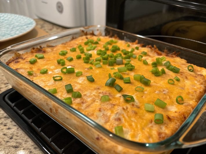 Baked high protein buffalo chicken dip topped with melted cheese