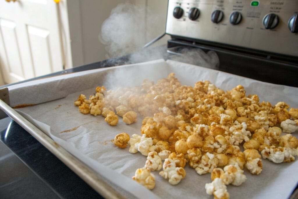 Hot honey popcorn on baking sheet before crisping